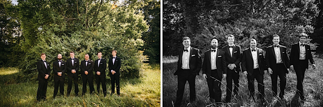 groomsmen in black tuxedos walk in a grassy field