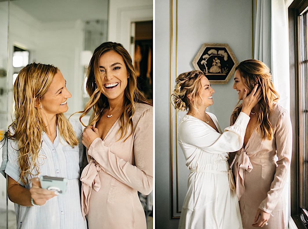 A bride and bridesmaid embrace while wearing silk dressing gowns.