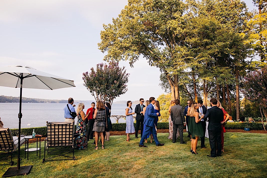 Wedding guests mingle at a big backyard wedding.