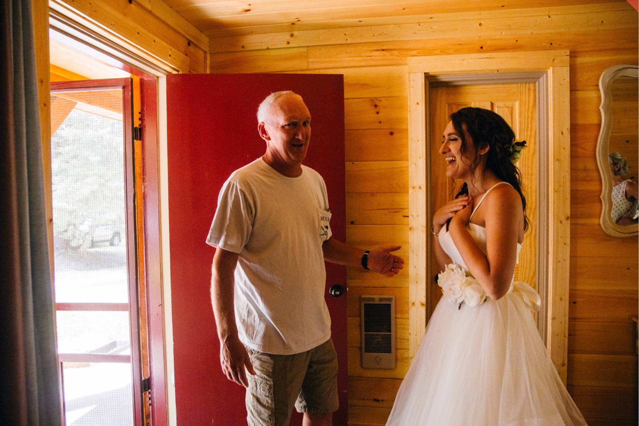 The bride laughs and she sees her father for the first time on her wedding day.