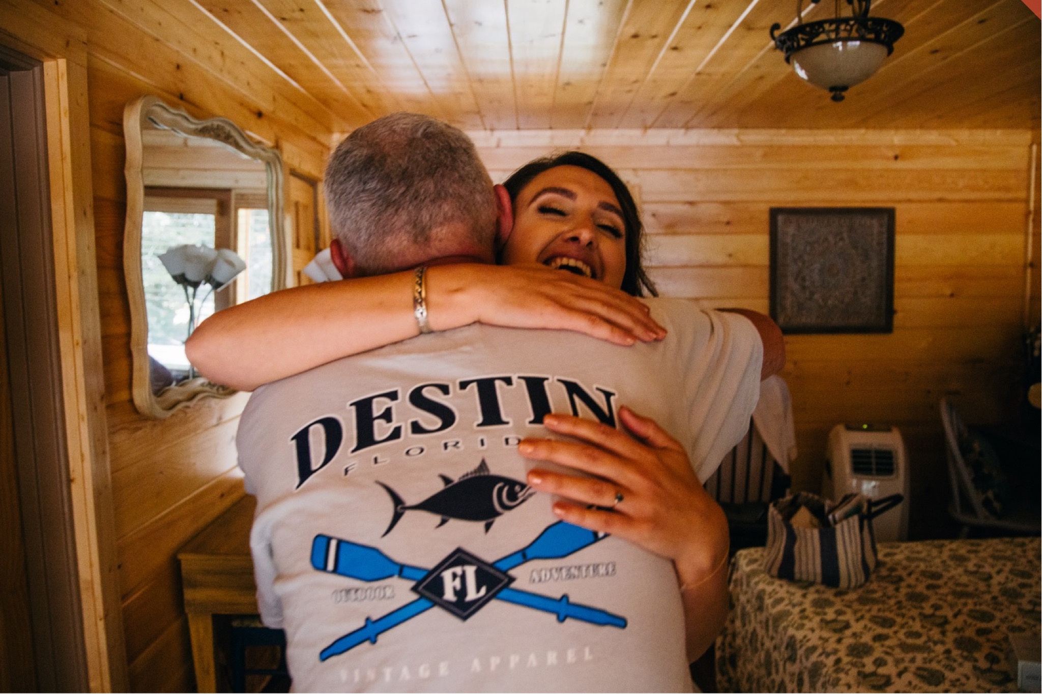The bride and her father hug in her getting ready cabin.