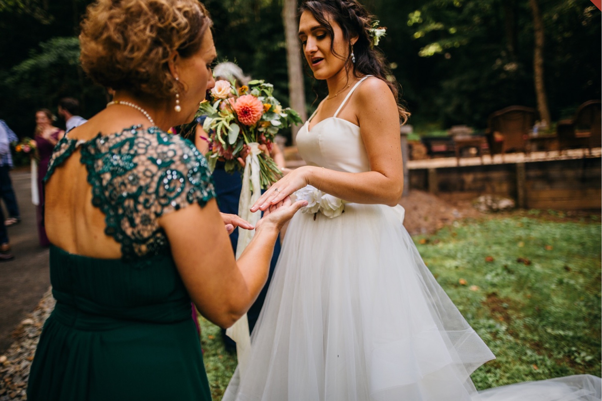 The bride shows off her ring to a wedding guest.