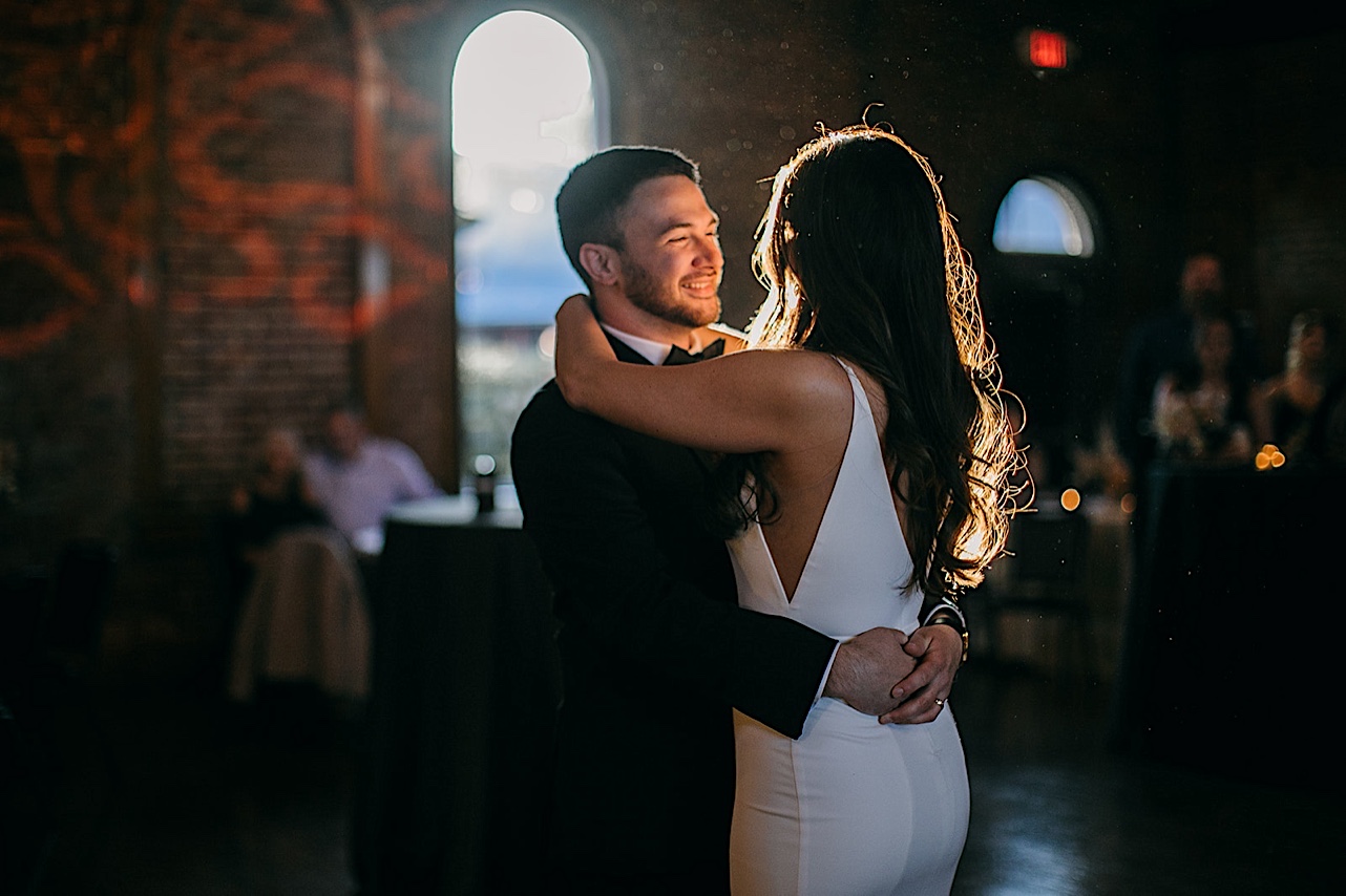 The bride and groom smile at one another during their first dance.