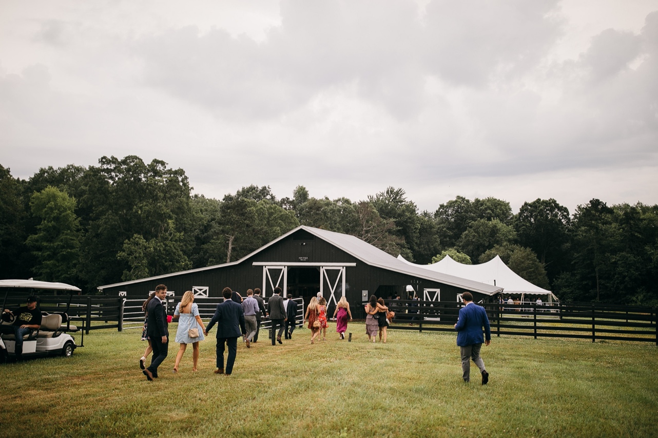Wedding guests walk into a barn on the family farm.