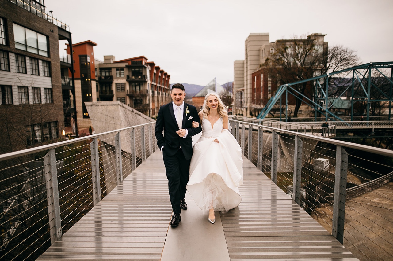 Bride and groom walk together across a footbridge in Chattanooga.