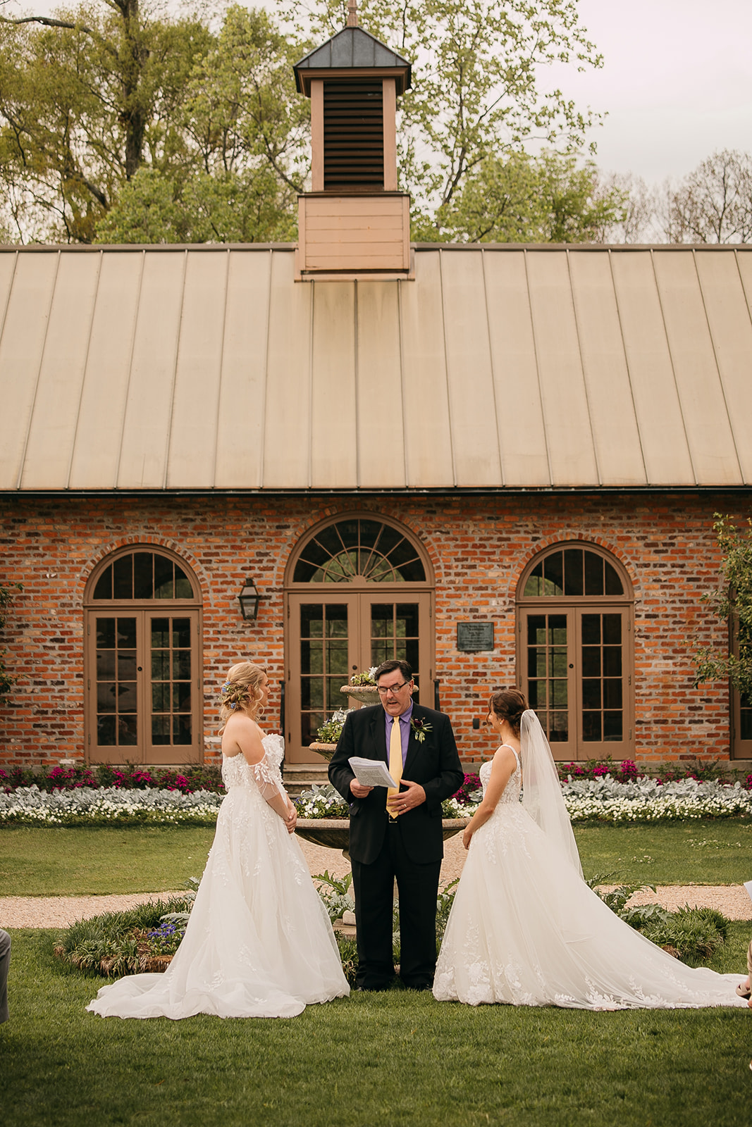 Bride and bride exchange vows at LSU AgCenter Botanic Gardens wedding ceremony