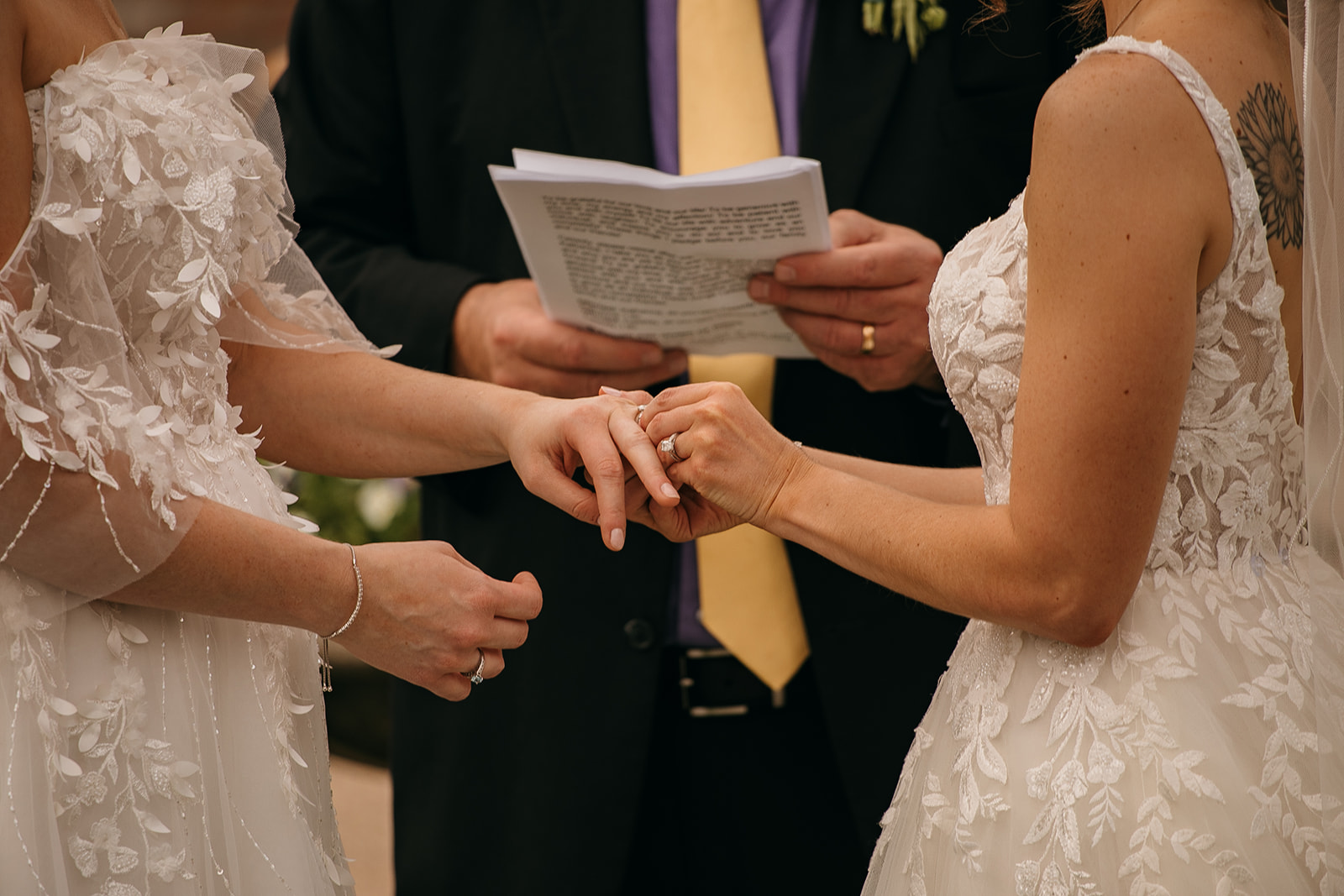 Bride and bride exchange rings at LSU AgCenter Botanic Gardens wedding ceremony