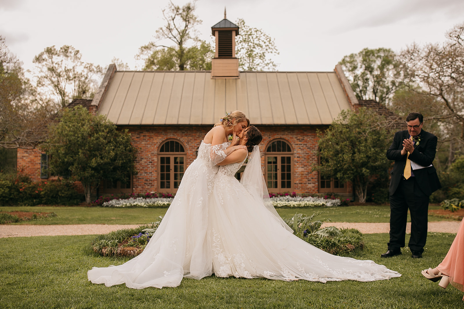 Bride and bride kiss at LSU AgCenter Botanic Gardens wedding ceremony