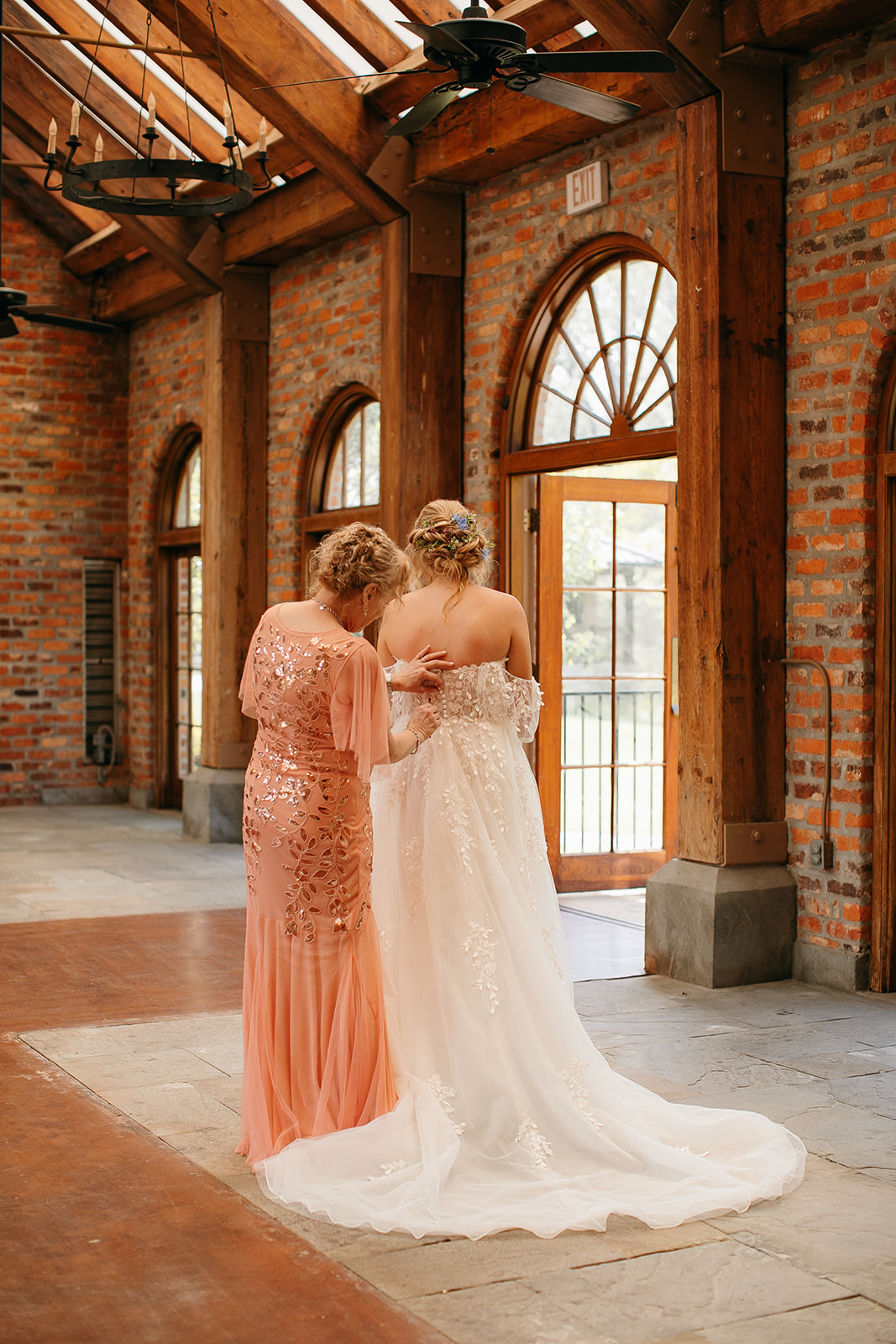 Bride's mom zipping the wedding dress at her LSU Botanical Gardens wedding