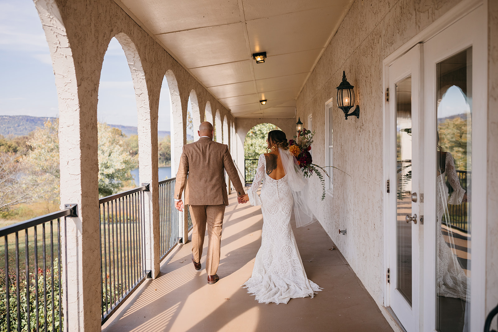 Romantic bride and groom portrait walking on balcony holding hands at one of the top outdoor wedding venues Chattanooga, TN. 