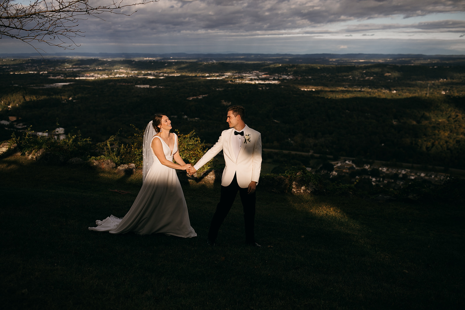 Bride and groom walking together on a mountain with views behind them at one of the top outdoor wedding venues near Chattanooga, TN