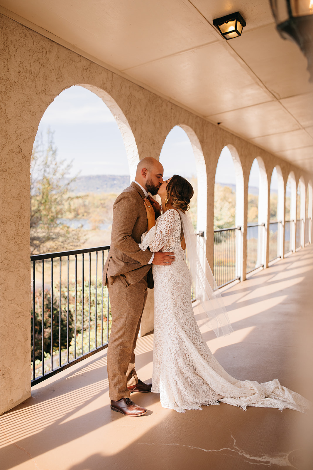 Bride and groom sharing a kiss along the arched walkway at a Tennessee River Place wedding. 