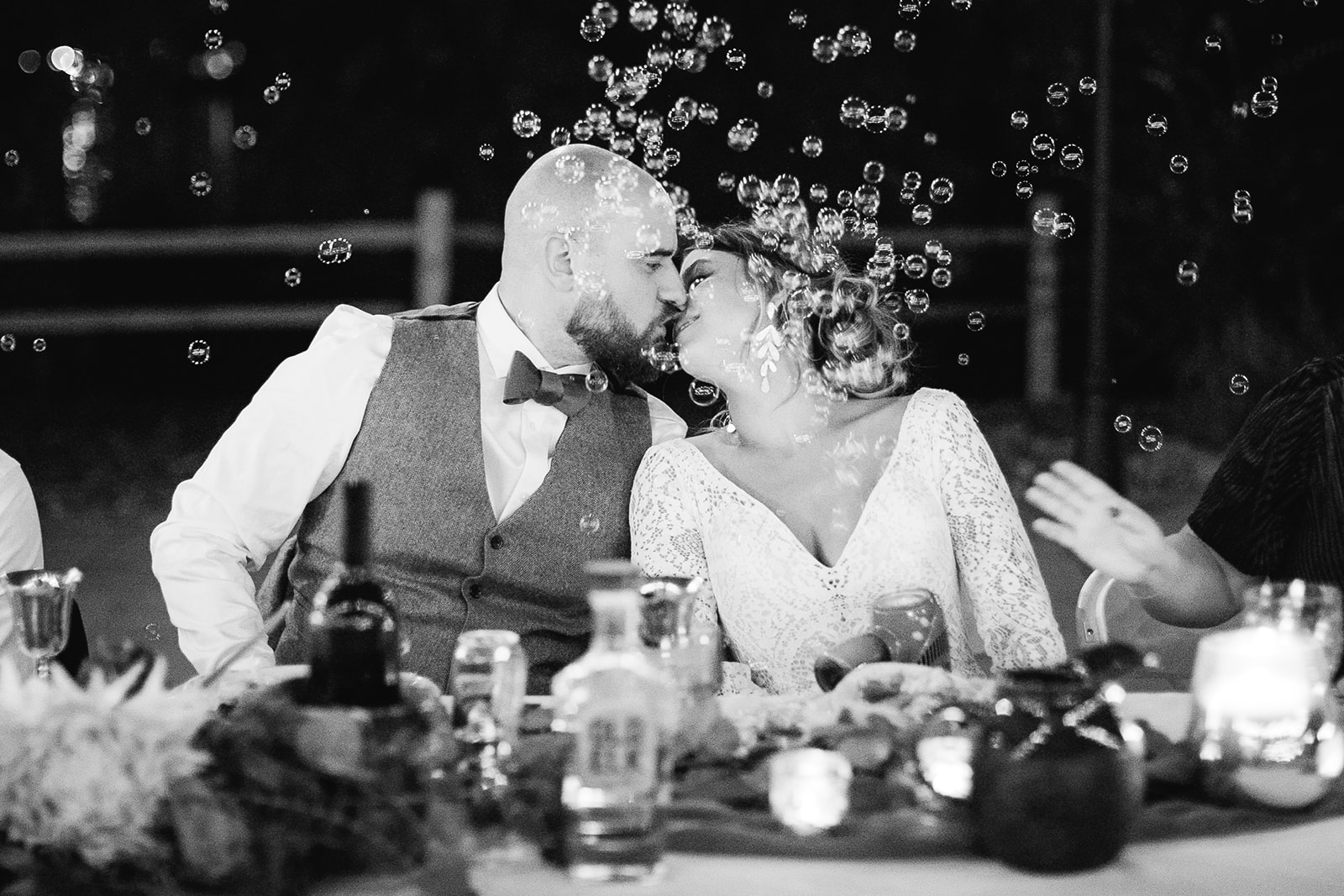Black and white reception moment with the couple kissing under bubbles at Tennessee River Place Chattanooga