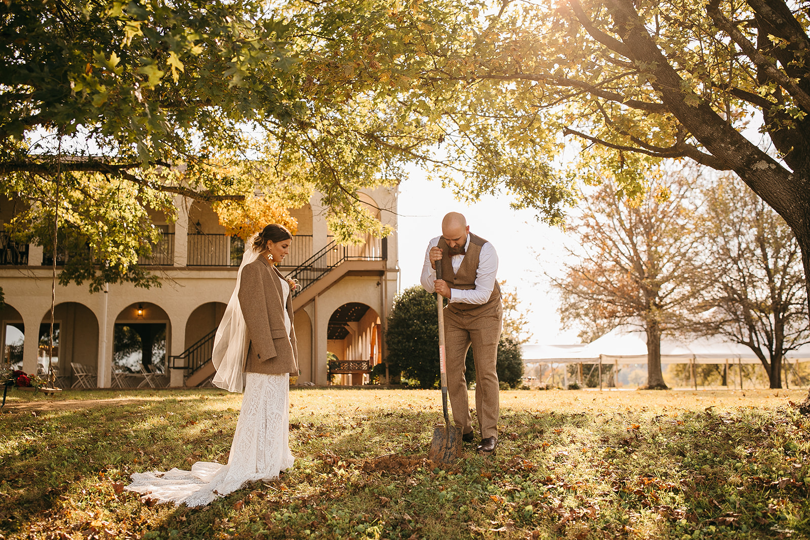 Bride and groom digging a hole together during a Tennessee River Place photos moment outdoors. 