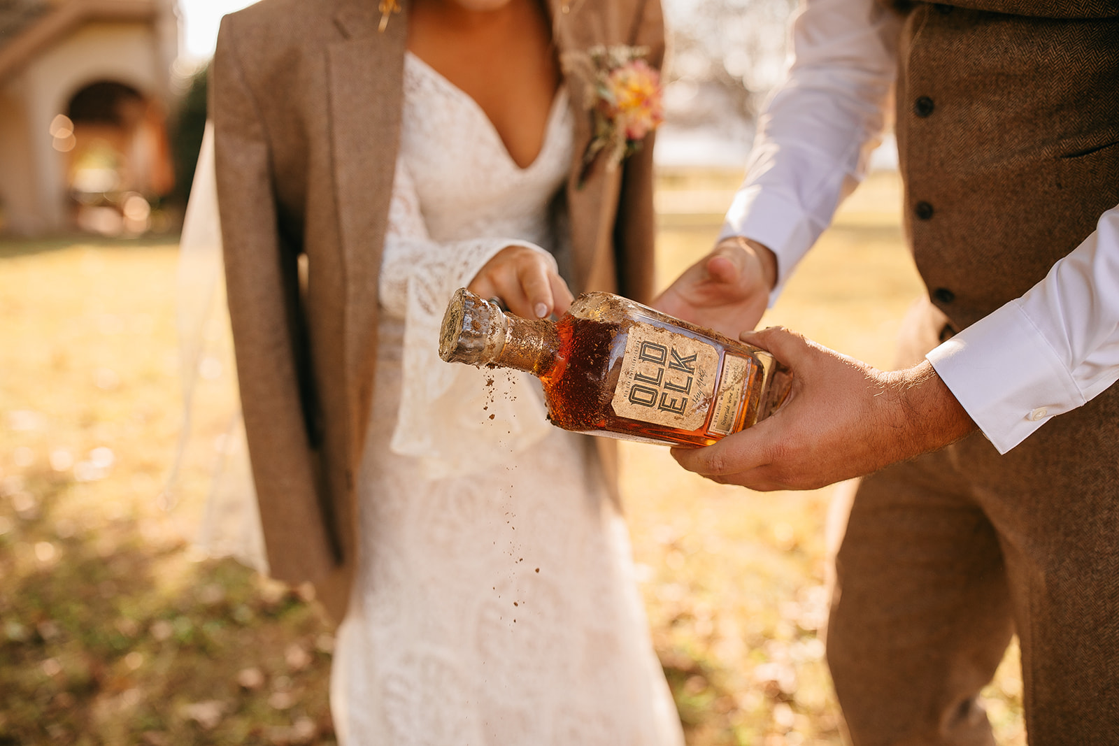 Holding a bottle of whiskey for unique Tennessee River Place photos. 