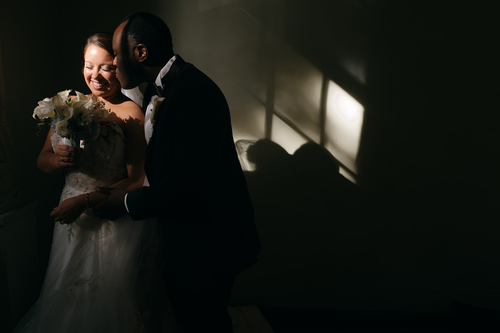 Romantic portrait of the bride and groom inside the Atlanta Biltmore Ballrooms with dramatic window light and shadows. 