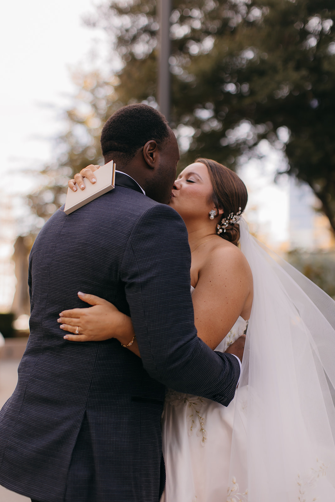 Bride and groom sharing a kiss outside before their wedding ceremony at The Biltmore Ballrooms Atlanta.