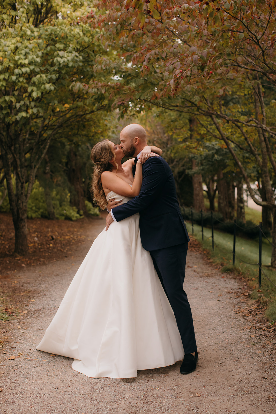 Bride and groom sharing a portrait beneath fall foliage at a garden wedding venues NC location in Asheville. 