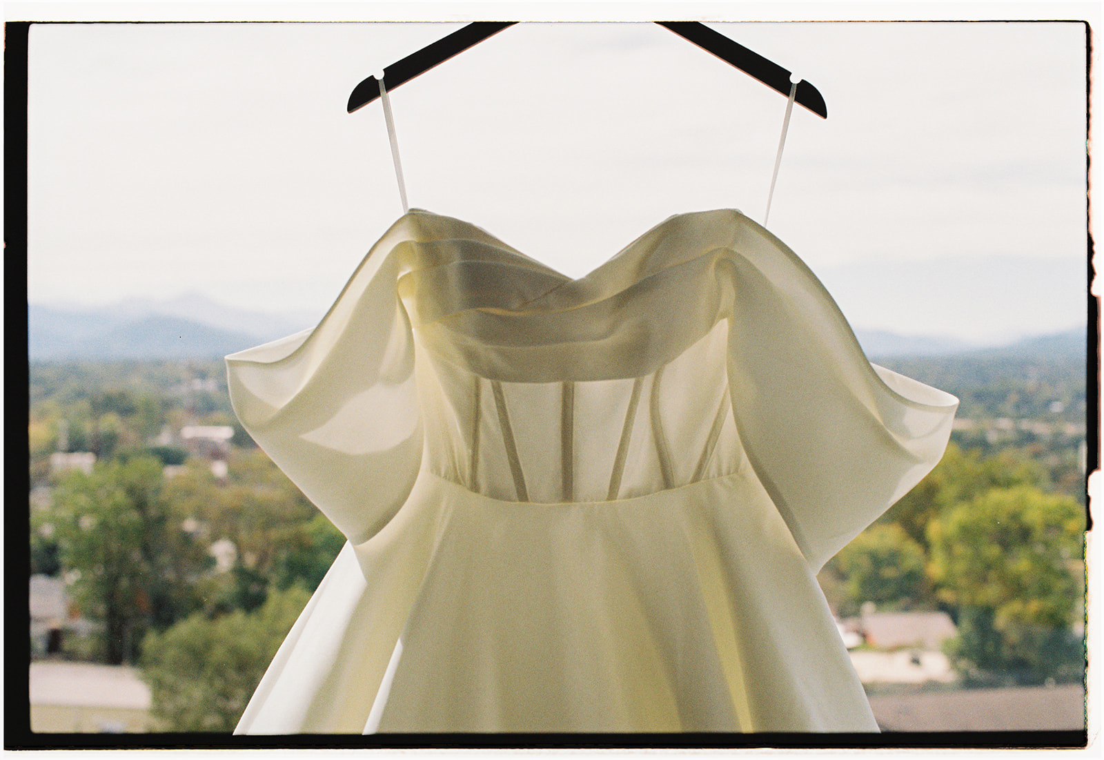 Wedding dress hanging in front of mountain views before an NC Arboretum wedding in Asheville. 
