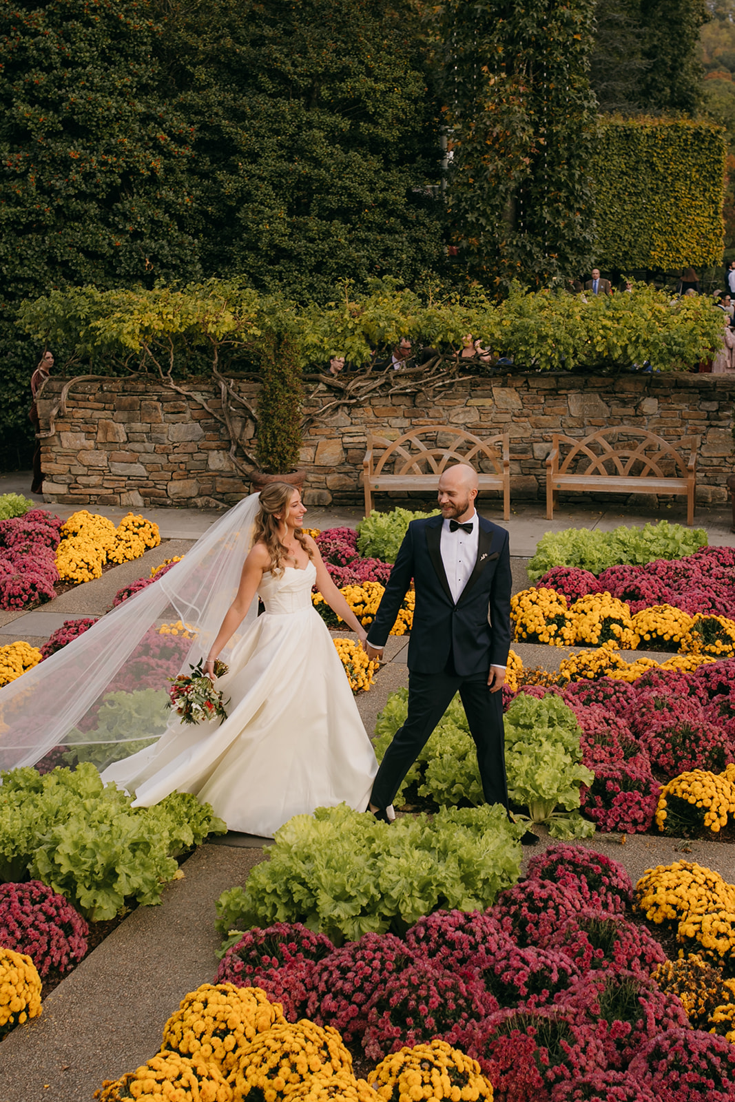 Bride and groom walking through the formal gardens during an NC Arboretum wedding in Asheville