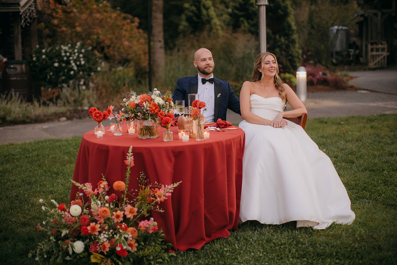 Bride and groom seated at their sweetheart table during one of the many beautiful NC Arboretum weddings. 