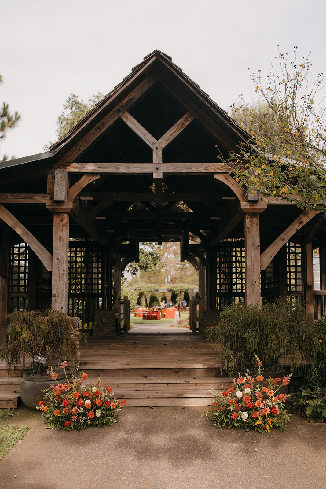 Ceremony site prepared for an NC State Arboretum wedding with seasonal florals and garden surroundings. 