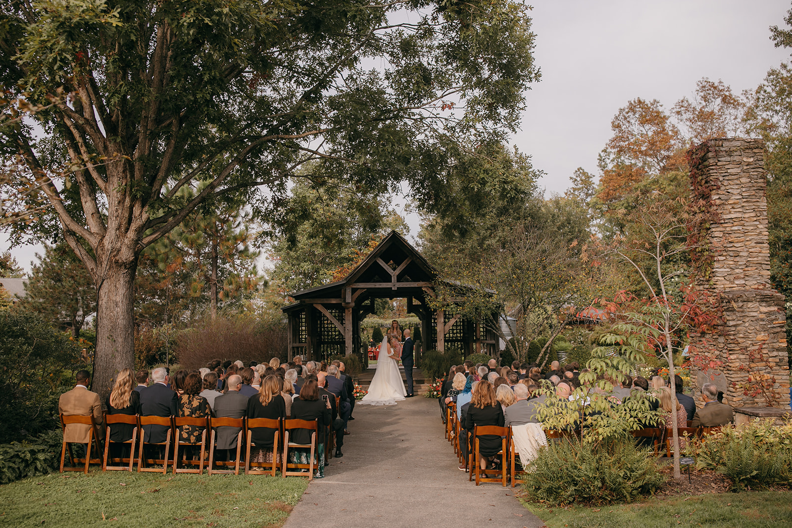 Guests gathered for an outdoor NC State Arboretum wedding ceremony in the gardens.