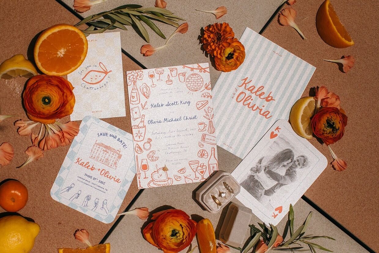 wedding invitations at common house chattanooga with oranges and greenery surrounding them