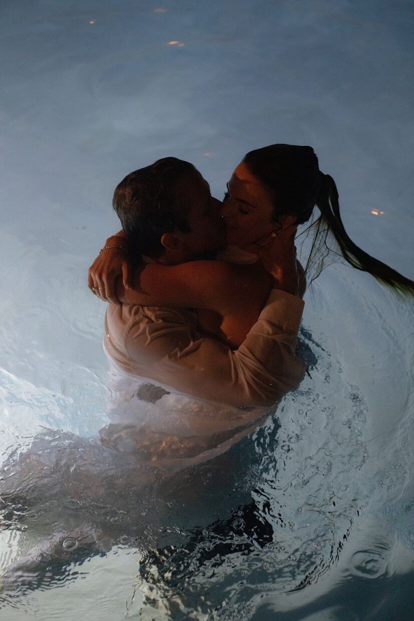 groom and bride kissing in pool after jumping in after reception at common house chattanooga