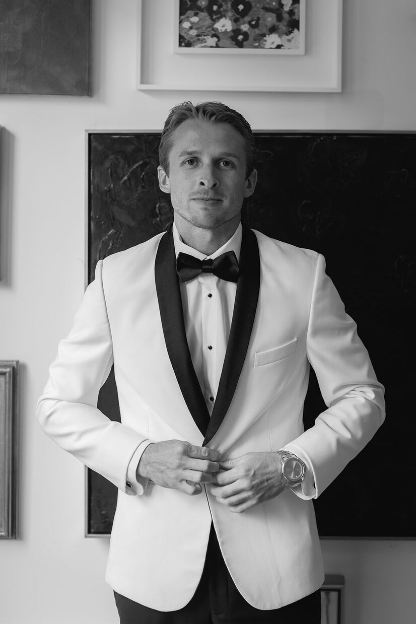 groom fixing suit while looking at camera at common house chattanooga
