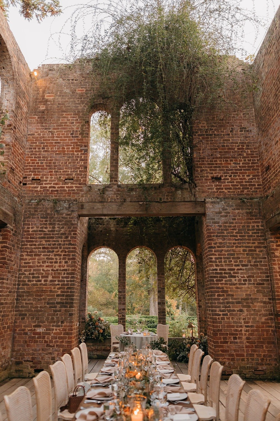 Reception space with towering arches and ruins of an old brick building for a Barnsley Gardens wedding.
