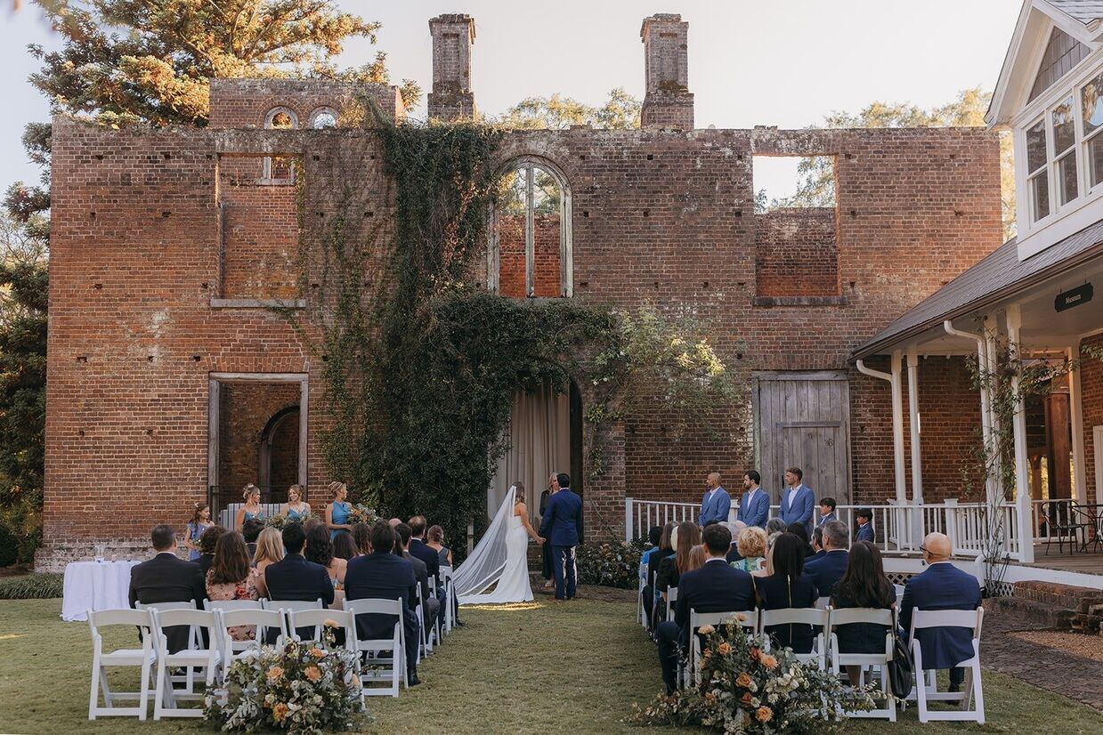 View of ceremony at Barnsley Garden wedding with exposed brick and archways